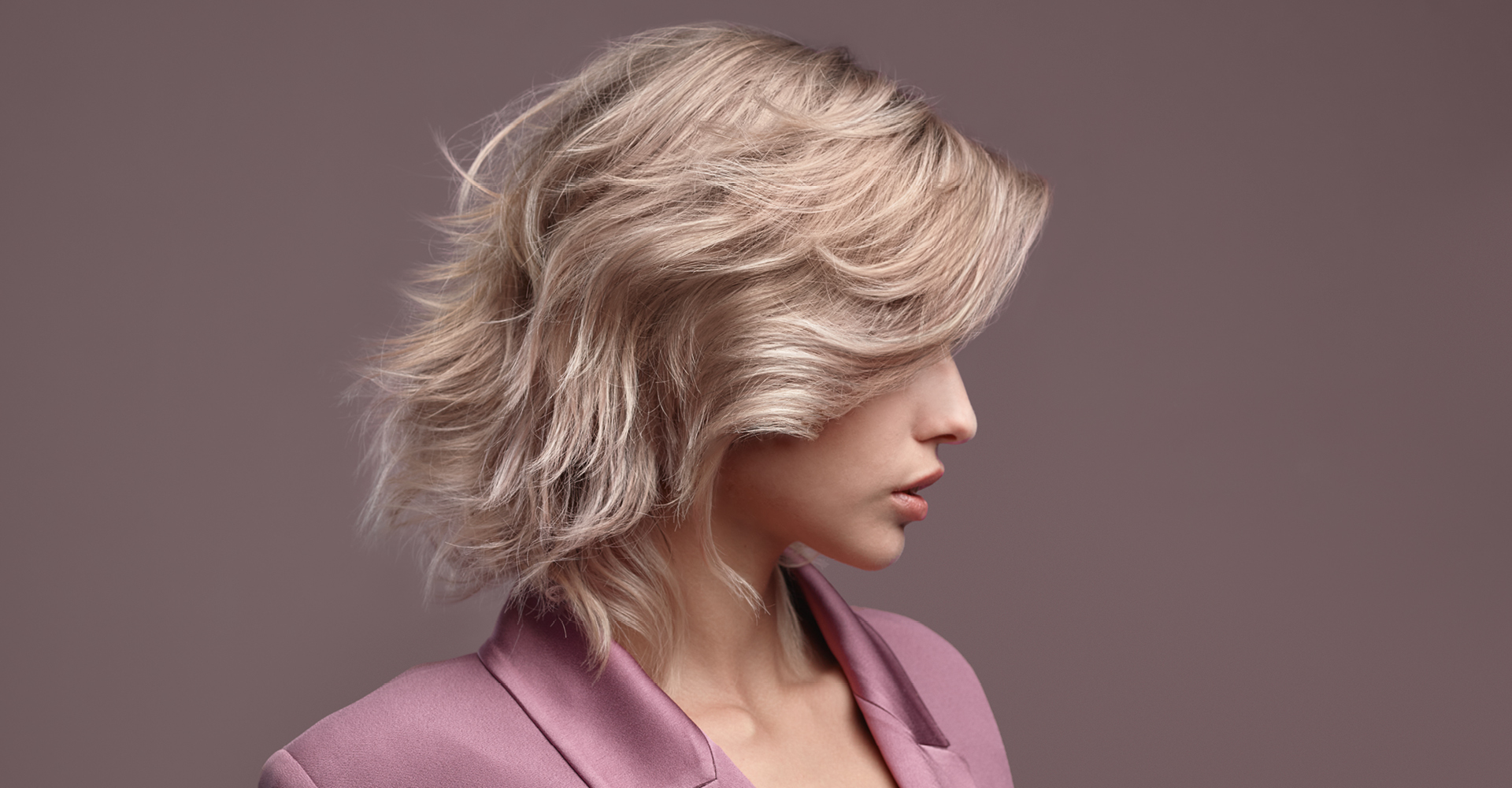 immagine ragazza con capelli biondi mossi che guarda a destra
